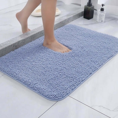 Person stepping onto a blue bath mat in a bathroom setting.
