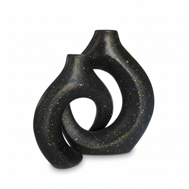 Black ceramic vase with a unique, abstract design on a white background