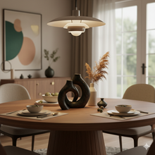 تحميل الصورة في عارض المعرض، Dining room with a round wooden table, decorative vases, and a pendant light.
