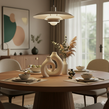 تحميل الصورة في عارض المعرض، Dining room with a wooden table set for a meal, modern pendant light, and decorative vases.
