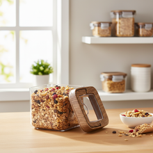 Load image into Gallery viewer, Glass jar with wooden lid filled with granola on a kitchen counter.
