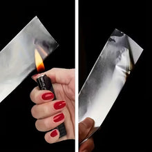 Load image into Gallery viewer, Person lighting a small object with tinfoil using a lighter, on a black background.
