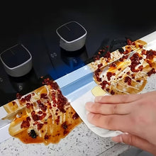 Load image into Gallery viewer, Two grilled items with red toppings on a white plate, with a hand holding a napkin, against a dark background.
