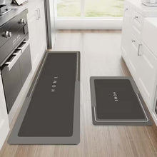 Load image into Gallery viewer, Two gray kitchen mats with 'HOME' text on a wooden floor in a kitchen setting.
