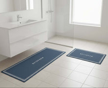 تحميل الصورة في عارض المعرض، Two blue bath mats with 'Bathroom' text on a tiled bathroom floor.
