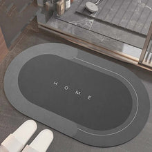 Load image into Gallery viewer, Gray bath mat with &#39;HOME&#39; text on a bathroom floor
