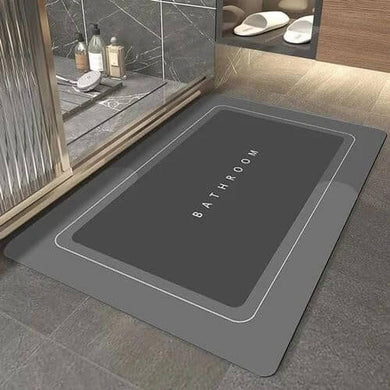 Gray bath mat with 'Bathroom' text on a bathroom floor.