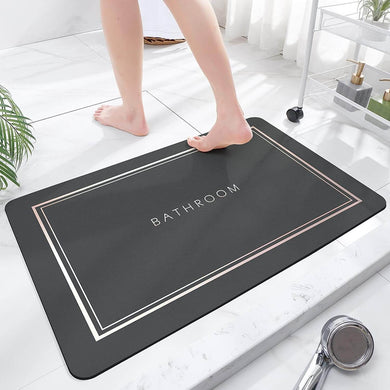 Black bathroom mat with 'Bathroom' text on a white floor.