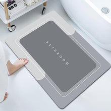 Load image into Gallery viewer, Gray bath mat with &#39;Bathroom&#39; text on a bathtub floor
