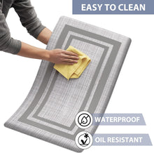 Load image into Gallery viewer, Person cleaning a gray and white patterned mat with a yellow cloth, text indicating ease of cleaning, waterproof, and oil-resistant properties.
