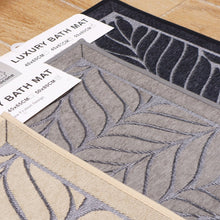 تحميل الصورة في عارض المعرض، Luxury bath mat with leaf pattern and promotional text on a wooden floor.
