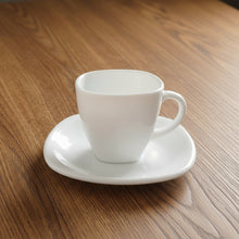 Load image into Gallery viewer, White ceramic cup and saucer on a light gray background
