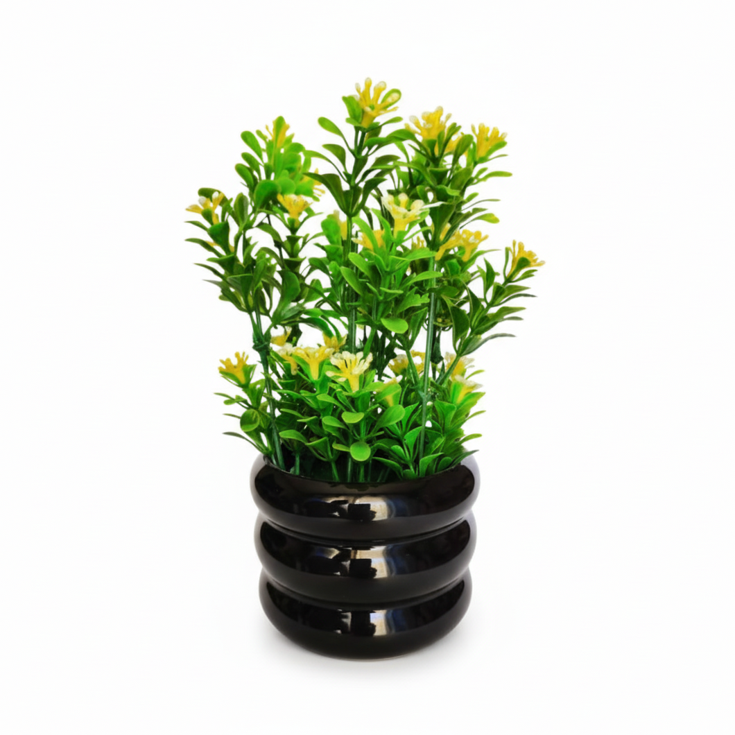 Artificial green plant in a black pot on a white background