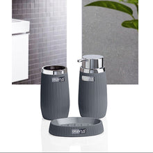 Load image into Gallery viewer, Gray bathroom accessory set with two ribbed cylindrical containers and a matching base, shown in front of a bathroom interior background with tiled wall and green leaves.
