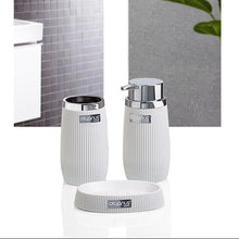 Load image into Gallery viewer, A set of three white bathroom toiletry containers with ribbed textures and chrome-finished lids, including a small round dish, shown against a split background of a gray tiled wall and a gray concrete wall with a green leaf.
