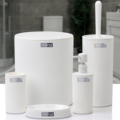 Set of white bathroom accessories including a toilet brush holder, bottle, and container on a white surface with a blurred bathroom background.