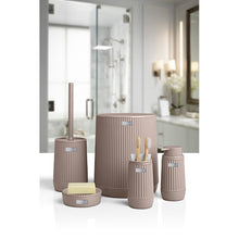 Load image into Gallery viewer, A coordinated bathroom toiletry set in a warm taupe-beige ribbed finish, including a tall toilet brush holder, a cylindrical container, a toothbrush holder, a small soap dish, and a small cup, shown in front of a softly blurred modern bathroom interior.
