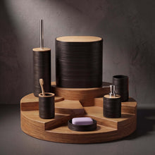 Load image into Gallery viewer, A coordinated bathroom or vanity set made of dark ribbed wood with light natural wood tops, arranged on a round wooden base against a dark gray studio background. The set includes a tall cup, a toothbrush holder with a toothbrush, a soap dish with a lavender bar of soap, a pump bottle, and a small cylindrical container.

