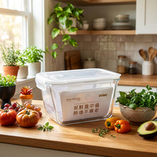 Load image into Gallery viewer, Clear food storage container with white interior on a wooden surface, featuring text and branding.
