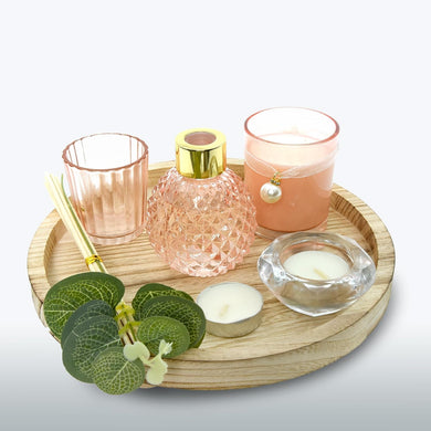Decorative items including candles and a diffuser on a wooden tray with a light background