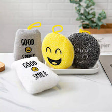Load image into Gallery viewer, A set of four multi-purpose cleaning sponges in different colors, each with a cheerful face and text elements, displayed on a kitchen counter.
