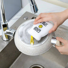 Load image into Gallery viewer, Person washing a white sponge with black text in a sink.
