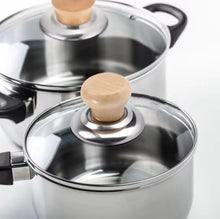 Load image into Gallery viewer, Two stainless steel saucepans with clear glass lids and light wood knob handles, shown on a clean white background.
