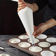Load image into Gallery viewer, Cream pastry bag being used to fill cupcake liners for cake decoration, showcasing professional and efficient baking.
