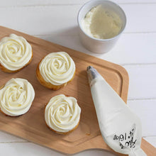Load image into Gallery viewer, Professional cream pastry bag beside decorated cupcakes on a wooden board, perfect for cake decoration.
