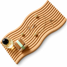 تحميل الصورة في عارض المعرض، A wavy, ribbed light wood tray styled with jewelry accessories, including gold necklaces, earrings, beads, and a small bottle, on a solid white background.
