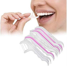 Load image into Gallery viewer, A collection of dental floss picks in various colors displayed in a row, with one pick being used by a person to floss their teeth.
