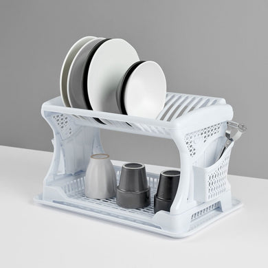 White dish rack with plates and cups on a gray background