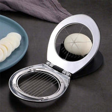 تحميل الصورة في عارض المعرض، Metallic egg slicer with a sliced egg on a dark surface
