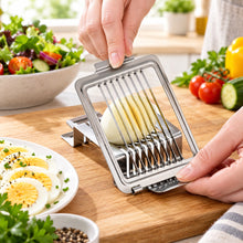 Load image into Gallery viewer, A stainless steel multi-slice slicer with a pale potato being sliced into thin rounds, held by two hands against a white background.
