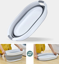 تحميل الصورة في عارض المعرض، Collapsible gray and white bucket with a person using it in a laundry setting.
