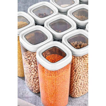 تحميل الصورة في عارض المعرض، A set of clear cylindrical spice jars with white lids, filled with various dried foods like lentils, beans, and grains, arranged on a gray surface.

