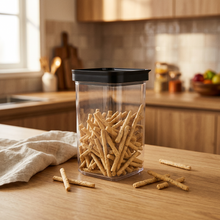 Load image into Gallery viewer, Clear container with black lid filled with snacks on a white background
