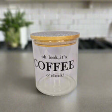 Load image into Gallery viewer, Glass jar with wooden lid labeled &#39;oh look, it&#39;s COFFEE o&#39;clock!&#39; on a kitchen counter.
