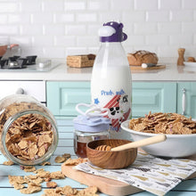 Load image into Gallery viewer, Glass milk bottle with cow-shaped lid on a breakfast table
