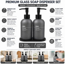 تحميل الصورة في عارض المعرض، A promotional infographic for a premium glass soap dispenser set, showing two matte black pump bottles with clear glass bodies and a matching black circular tray. The image includes feature callouts for bottles, pumps, leak-proof design, tray inclusion, and use in bathroom, kitchen, and laundry rooms, with small lifestyle photos along the bottom.

