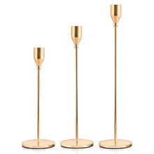 Load image into Gallery viewer, Three gold-finished metal candlesticks of different heights with round bases, shown against a plain white background.
