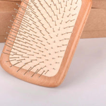 تحميل الصورة في عارض المعرض، Wooden hairbrush with metal bristles on a light background
