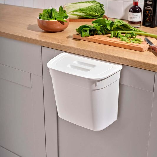 White hanging bin on a kitchen cabinet door