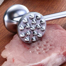 Load image into Gallery viewer, Metal meat tenderizer on a piece of raw meat with a wooden surface in the background
