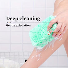 Load image into Gallery viewer, A person using a green exfoliating sponge on their leg in a tiled bathroom setting, with text overlay reading 'Deep cleaning' and 'Gentle exfoliation'.
