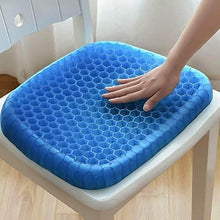 تحميل الصورة في عارض المعرض، Blue honeycomb seat cushion on a chair with a hand touching it.
