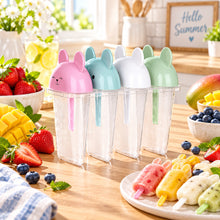 Load image into Gallery viewer, Four ice lolly moulds with pastel animal-shaped lids on a kitchen counter
