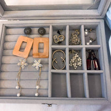 Load image into Gallery viewer, Jewelry box with various earrings neatly arranged on gray felt
