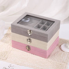 Load image into Gallery viewer, Stack of jewelry boxes in gray, beige, and pink on a textured surface.
