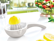 Load image into Gallery viewer, Manual lemon squeezer on a white surface with lemons and a salad in the background

